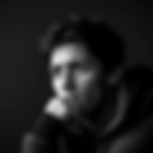 A person in thoughtful pose captured in black and white, expressing deep emotions through their gaze