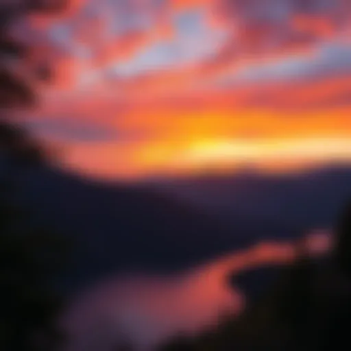 A vibrant sunset over a scenic landscape with mountains and a lake